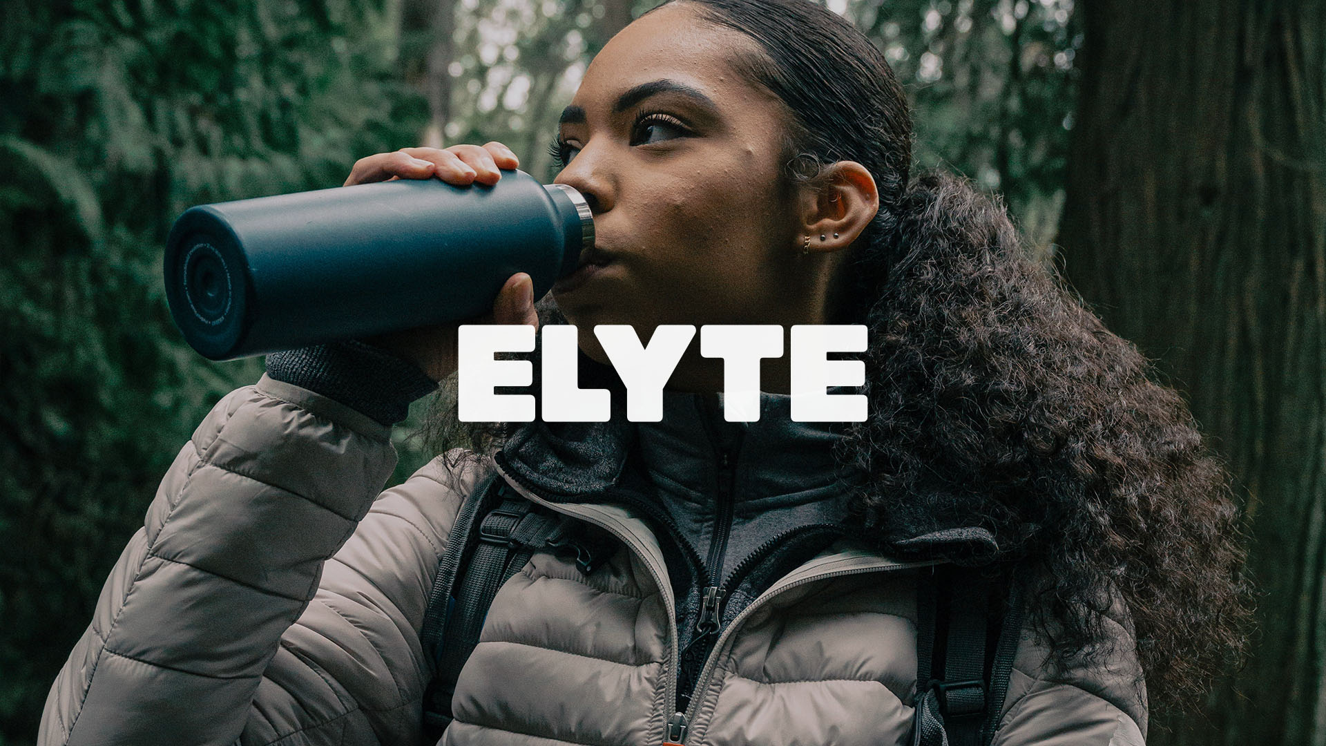 Elyte logotype in white on an image of a women drinking Elyte